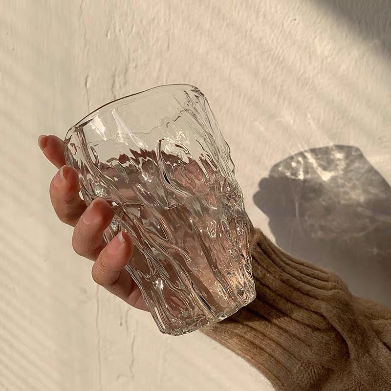 Hand holding a Crystal Wave Glass with a rippling design resembling crystal-clear water, perfect for adding elegance to your drinkware collection. Nest Haven Shop, GLASS, KITCHEN