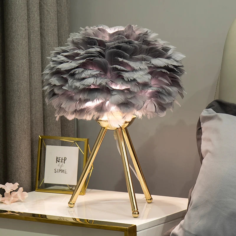 Soft and fluffy Feather Glow Lamp with elegant gold legs creating a warm ambiance on a nightstand. Perfect for adding charm to any BEDROOM, KID'S ROOM, or LIVING ROOM from Nest Haven Shop.