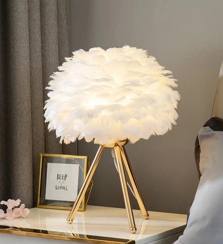 Elegant Feather Glow Lamp with fluffy white feather shade and gold legs, perfect for cozy ambiance. Ideal for Nest Haven Shop, BEDROOM, KID'S ROOM, LIVING ROOM