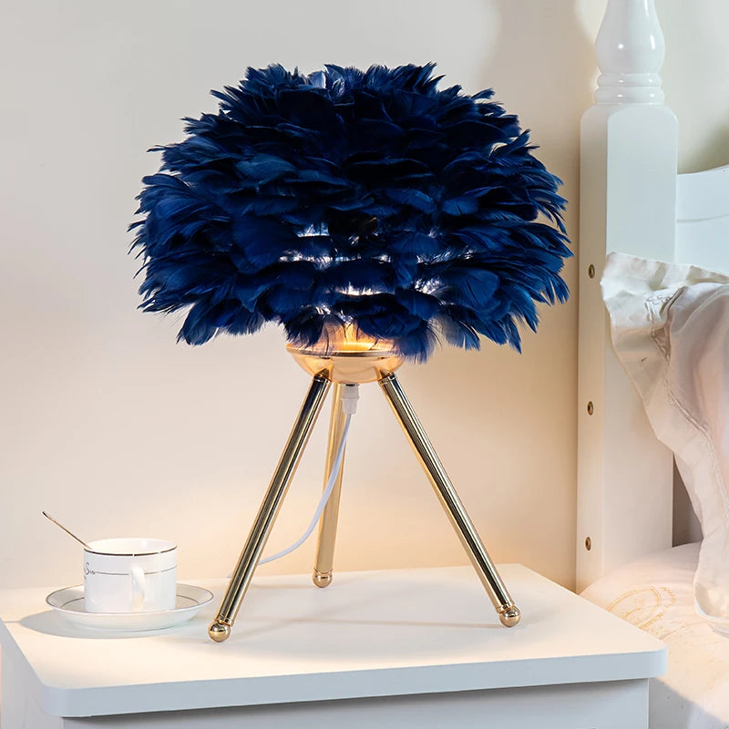 Feather Glow Lamp with a fluffy feather shade on elegant gold legs, perfect for adding charm to any room. Nest Haven Shop, BEDROOM, KID'S ROOM, LIVING ROOM