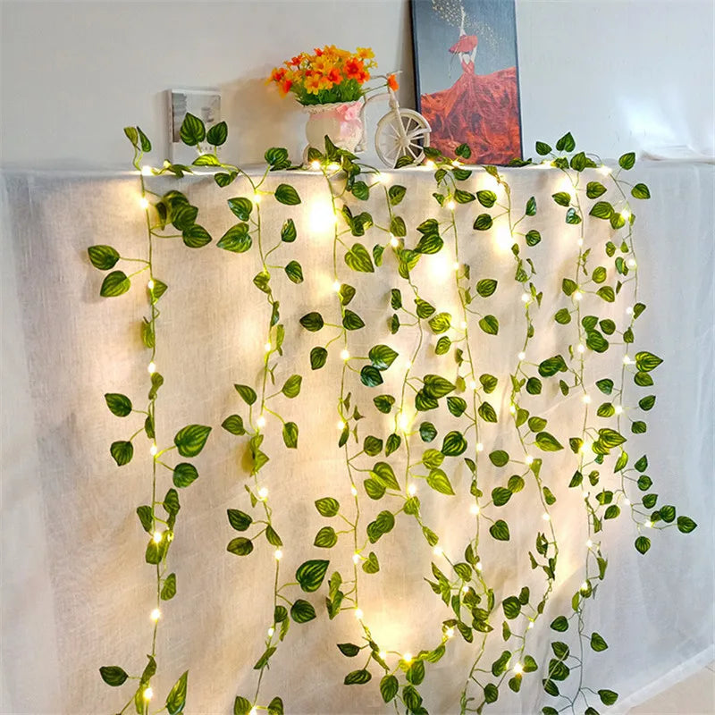 Leaf garland with glowing fairy lights, adding a magical touch to the decor, perfect for evening gatherings. Elegant green leaves paired with twinkling lights, ideal for indoor and outdoor ambiance. Nest Haven Shop, GARDEN