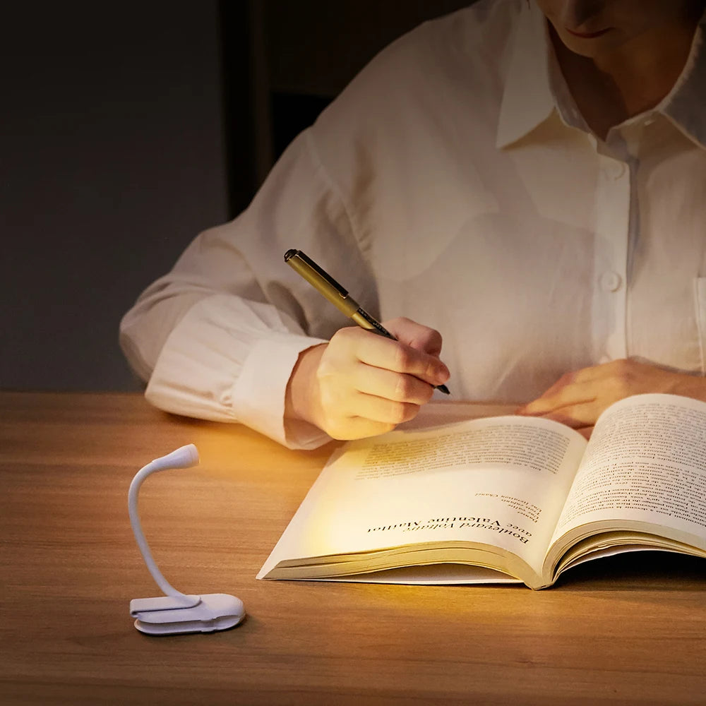 Portable book light with a 360° flexible neck and sturdy clip, providing soft LED light for easy reading without eye strain. Nest Haven Shop, BEDROOM.